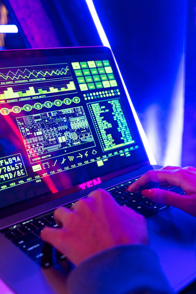 Person typing on a laptop with vibrant digital data display, highlighting cyber security.