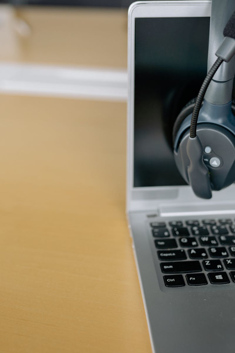 Close-up of wireless headset on laptop screen, ideal for communication tech visuals.